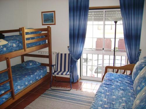 ナザレにあるCasa da praiaのベッドルーム1室(二段ベッド2組付)、バルコニーが備わります。