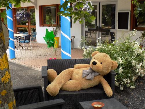 a large teddy bear sitting on a chair at NESTOR HOTEL GAP et Restaurant in Gap