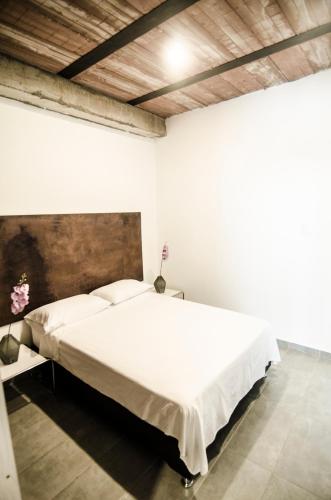 a bedroom with a large white bed in a room at Moonshine Boutique Hostal in Cali