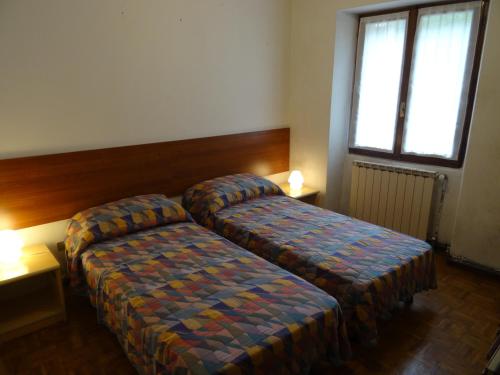 a hotel room with two beds and a window at Appartamento da Davide in Pieve Di Ledro