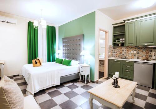 a bedroom with a bed and a kitchen with green cabinets at Charisma Boutique Hotel in Parga