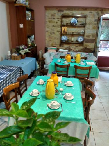 a restaurant with blue tables and yellow vases on them at Krini Rooms in Kambos