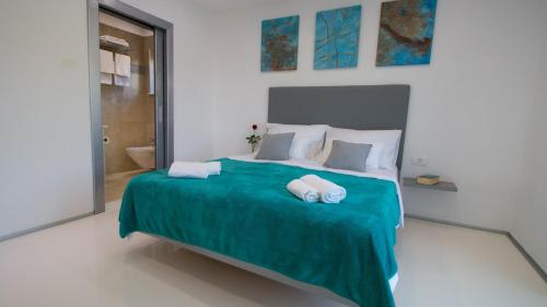 a bedroom with a bed with two towels on it at Organic Gardens Villa in Crikvenica