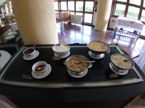 a table with bowls of food and cups of coffee at Satélite - Campos do Jordão in Campos do Jordão