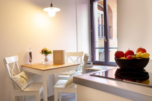 a kitchen with a table and a bowl of fruit at Borghese Apartment in Locarno