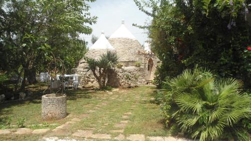 ein Steinhaus mit Garten davor in der Unterkunft Il Trullo del Cadetto in Francavilla Fontana