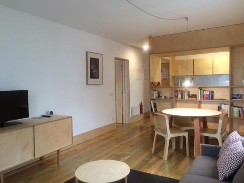 a living room with a table and a kitchen at SOBRE RIBAS 2|12 in Coimbra