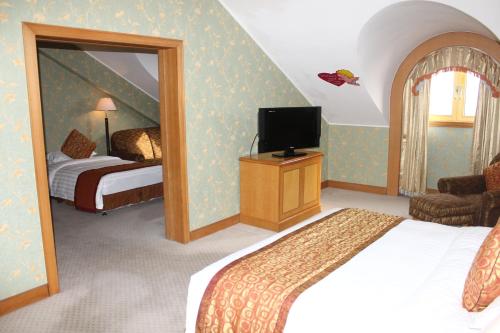 a bedroom with a bed and a tv and a mirror at Qingdao Oceanwide Elite Hotel in Qingdao
