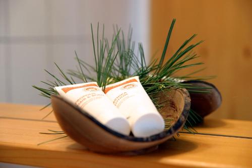 a wooden bowl with two rolled towels and a plant at AlmDorf Tonnerhütte in Mühlen