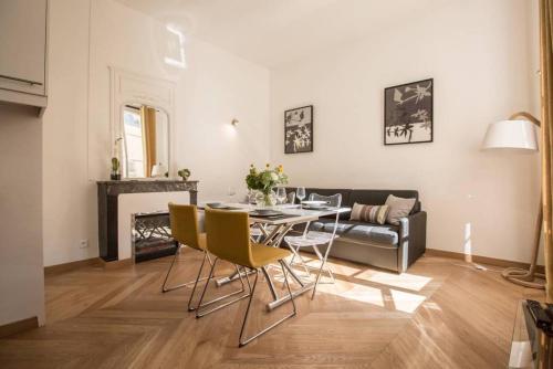 un salon avec une table, des chaises et un canapé dans l'établissement Remodeled Parisian Apartment, à Paris