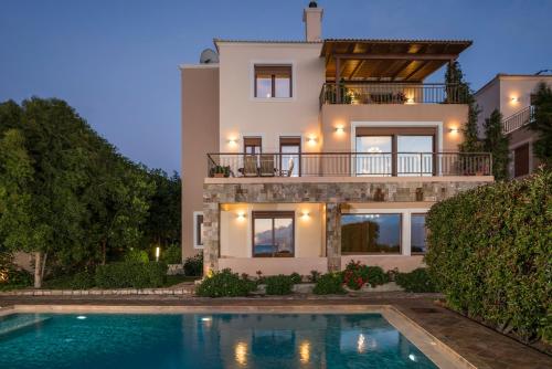 Villa con piscina frente a una casa en Caneva Luxury Villa en Tavronitis