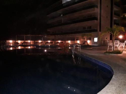 a swimming pool at night with a slide at Apto Le Bon Vivant Vista Mar in Arraial do Cabo