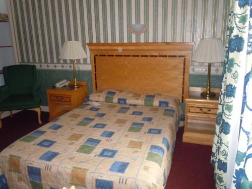 a bedroom with a bed and two lamps and a chair at La Croix Blanche in Montrichard