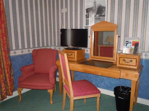 a room with a desk with a television and a chair at La Croix Blanche in Montrichard
