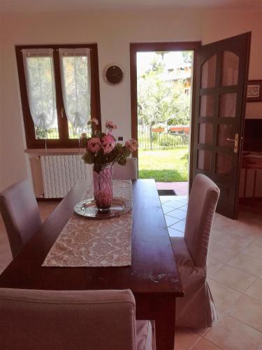 a dining room table with a vase of flowers on it at CASA NAVLA' AppartamentI "Ulivi"- "Fiori" -"Velieri"-"Luna"-"Nido"-"Taverna" in Tignale