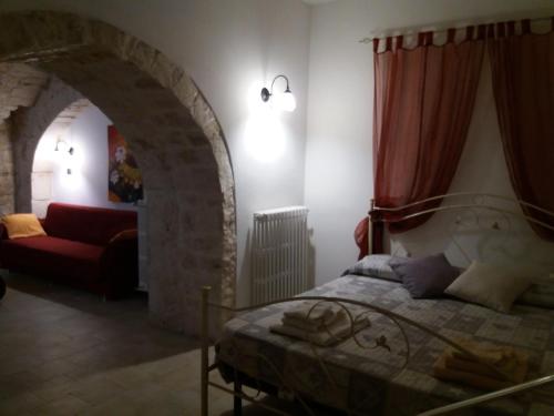 a bedroom with a bed and a red couch at Il rifugio del conte in Conversano