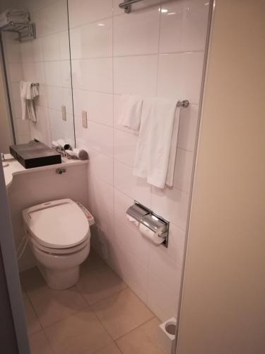a small bathroom with a toilet and towels at Hotel Metropolitan Akita in Akita