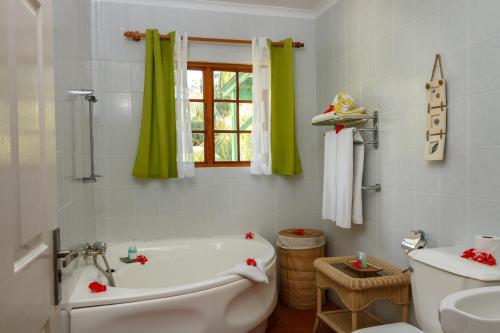 y baño con bañera, aseo y lavamanos. en L'Habitation Cerf Island, en Isla de Cerf