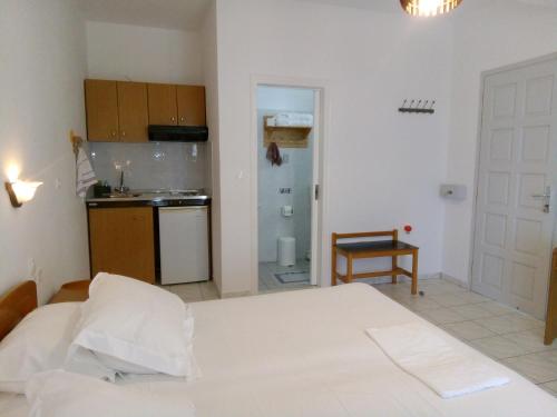 a kitchen with a white bed in a room at Studios Evdokia in Platis Gialos