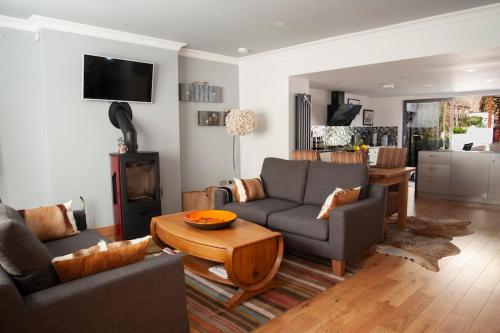 a living room with a couch and a table at Boutique cottage central Wells in Wells