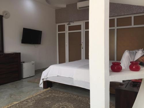 a bedroom with a bed and a flat screen tv at Oriental Nights Rest House in Al Wāşil