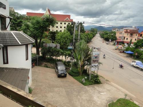a car parked in a parking lot next to a street at Charming Lao Hotel in Ban Chéng
