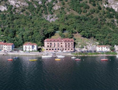 a group of boats in the water in front of a building at Hotel Bellavista in Valmadrera