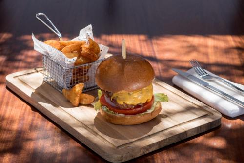 a sandwich and a basket of fries on a wooden tray at Amber Light Villas in Imerovigli