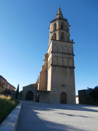 a tall building with a clock tower on a street at Chambres d'Hôtes d' En Jouti in Avignonet-de-Lauragais
