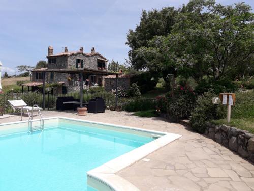 a swimming pool in front of a house at Agriturismo Cantinaccia di Sopra in Pitigliano