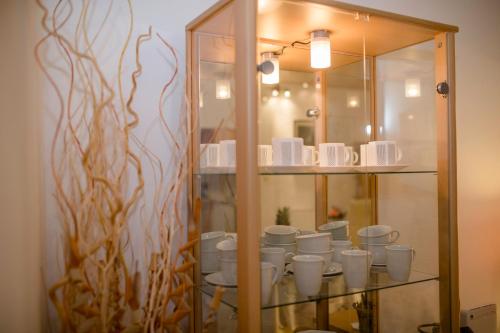 a glass cabinet with white cups in it at Apartment Patricia in Rab