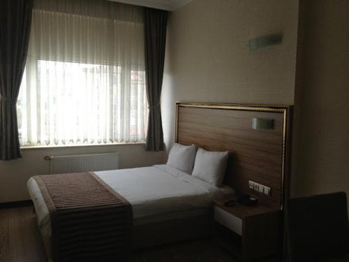 ein Hotelzimmer mit einem Bett und einem Fenster in der Unterkunft Buyuk Hotel in Kayseri