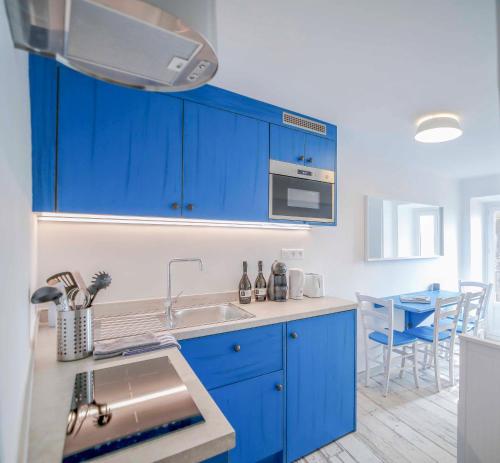 - une cuisine bleue avec évier et comptoir dans l'établissement Faro di Capo Testa, à Bonifacio