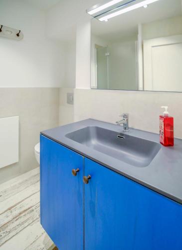 une salle de bain avec un lavabo bleu et un miroir dans l'établissement Faro di Capo Testa, à Bonifacio
