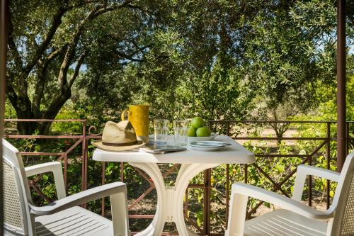 a white table and chairs on a patio with trees at Dendrolivano in Minia