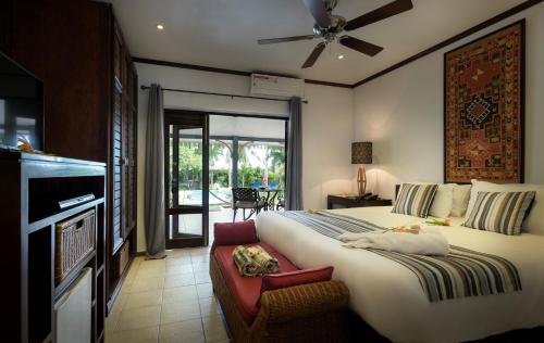 a bedroom with a large bed and a couch at Auberge Chez Plume in Anse Boileau