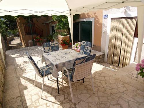 a table and chairs under an umbrella on a patio at Teo in Veli Lošinj