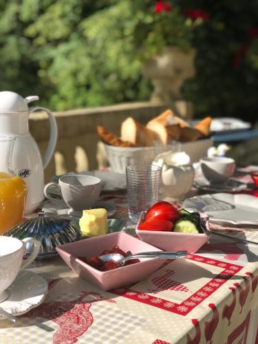 a table with a plate of food and a bowl of fruit at Villa Léovil in Saint-Pompont