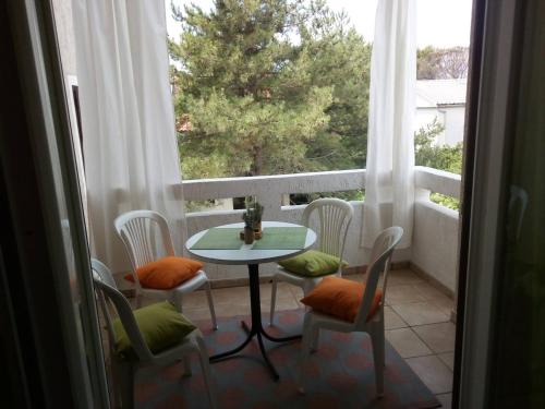 een balkon met een tafel en stoelen en een raam bij Studio Relax Punat in Punat
