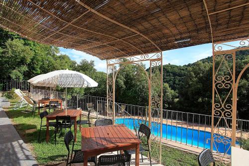 a patio with tables and chairs next to a pool at Locanda degli Alberi in Sassetta