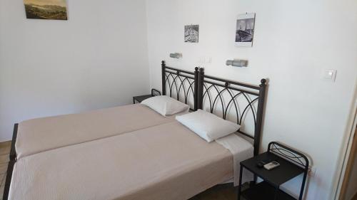a bed in a room with a white wall at Maroudas Stavros Apartments in Vathi