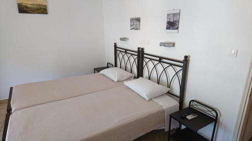 a bed in a room with a white wall at Maroudas Stavros Apartments in Vathi, Ithaka