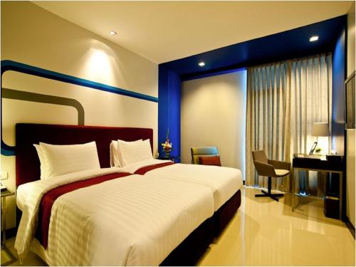 Habitación de hotel con cama grande y escritorio. en FX Hotel Metrolink Makkasan en Bangkok