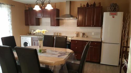 eine Küche mit einem Tisch und einem weißen Kühlschrank in der Unterkunft Gloria Ivana in Bibinje