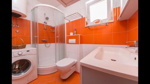 a bathroom with a washing machine and a sink at ID Luxury Apartment in Brela