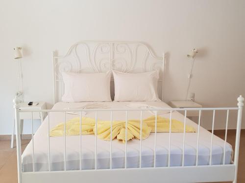 マタラにあるStudio Veronikiの白いベッド(白い枕、黄色い毛布付)