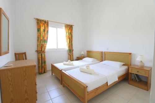 1 Schlafzimmer mit 2 Betten und einem Fenster in der Unterkunft Limnaria H in Paphos City