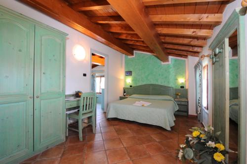 a bedroom with a bed and a desk in a room at Agriturismo Lizzarola in Peschiera del Garda