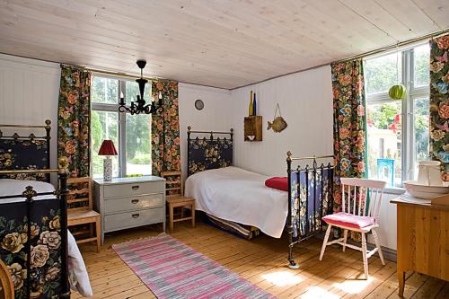 a bedroom with a bed and a desk and windows at Berte Bed&Breakfast in Slöinge