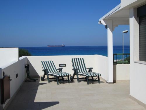 2 Stühle auf einer Terrasse mit Meerblick in der Unterkunft DueAttici e un Pianoterra in Gallipoli